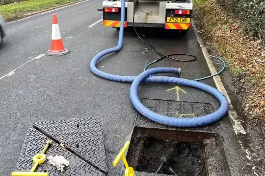 The Grey-Water Drainage vacuum tanker set up at a manhole.