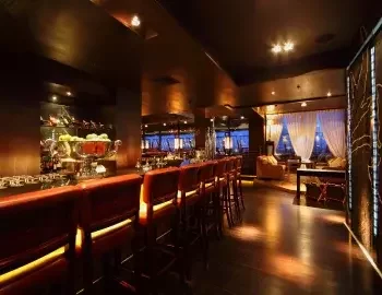 Interior of a bar with dark wood flooring.