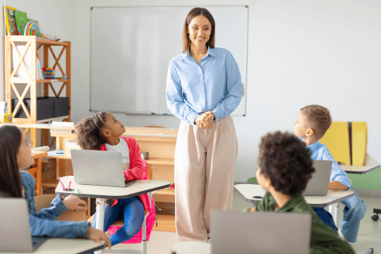 A teacher conducts a class in a tidy classroom.