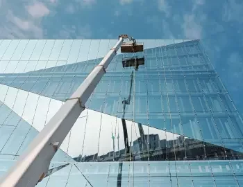 A mobile elevated work platform is used to deliver window cleaning to the exterior of a tall building, made up entirely of windows.
